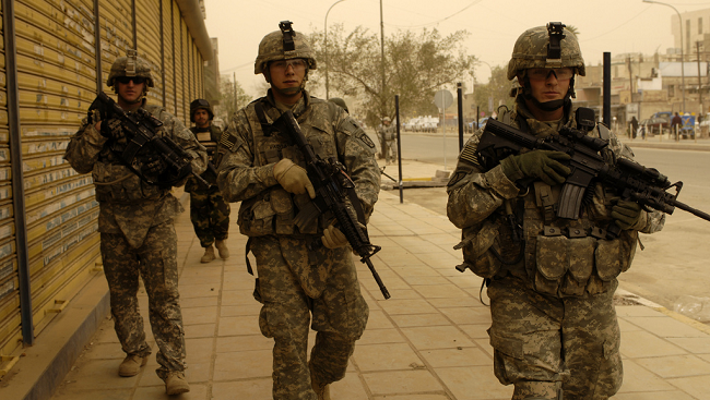 Three soldiers in tan army fatigues. 