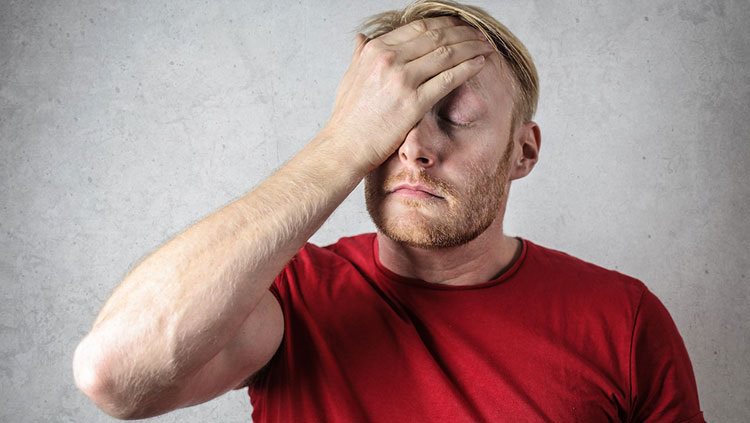 Man stressed with hand on his face