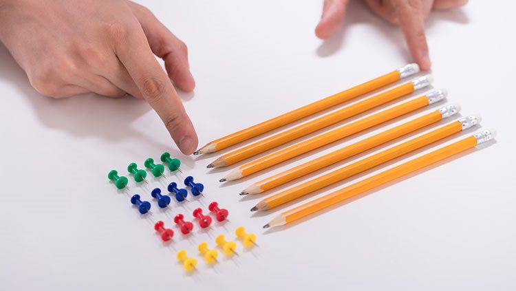 Pencils and thumbtacks lined up straight