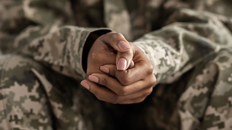 Woman in army uniform with hands crossed