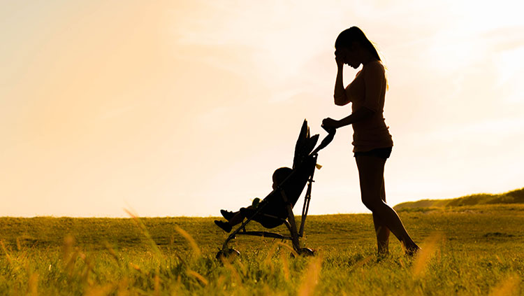 Woman with hand on head walking with stroller