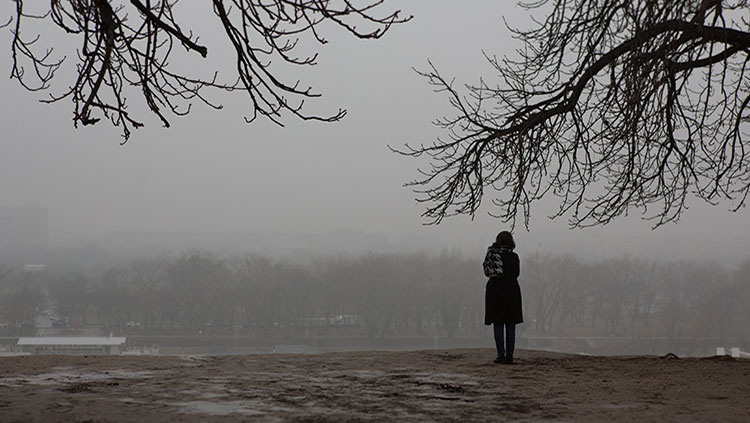 Person standing under tree in gloomy weather