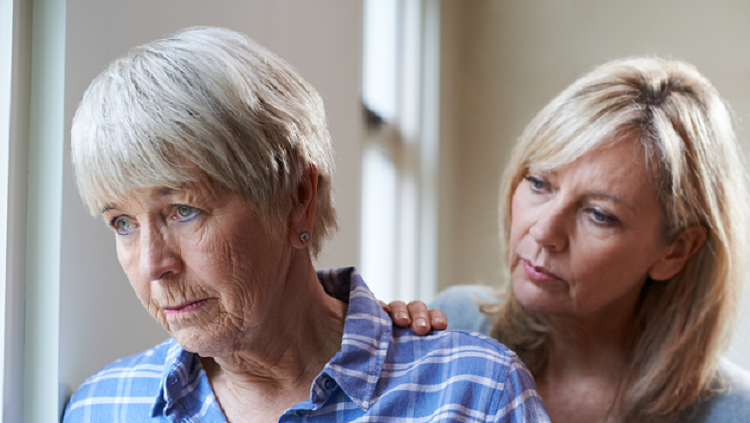 Image of elderly woman being comforted by younger adult