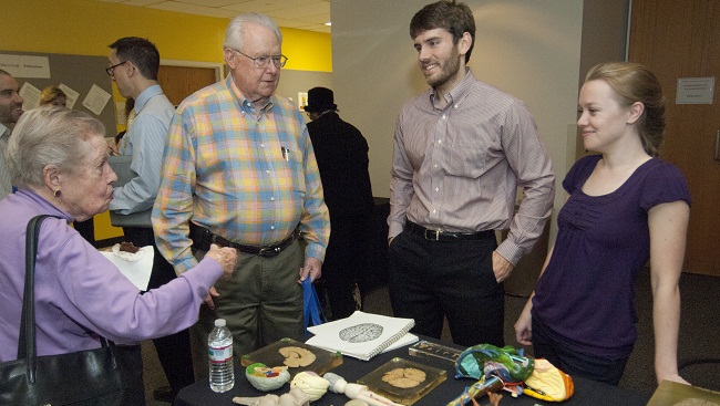 Graduate students talking to attendees