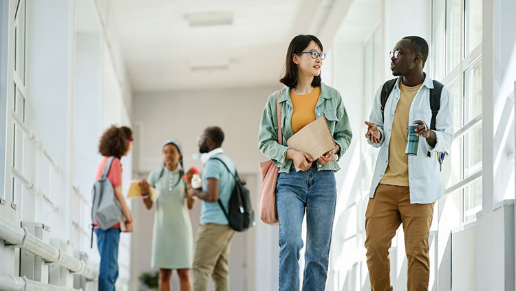 Teens walking down school hallway