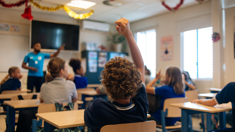 Kid raising hand in classroom