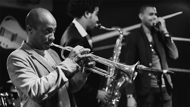 Black and white photograph of musicians; one playing trumpet and the other playing the clarinet.