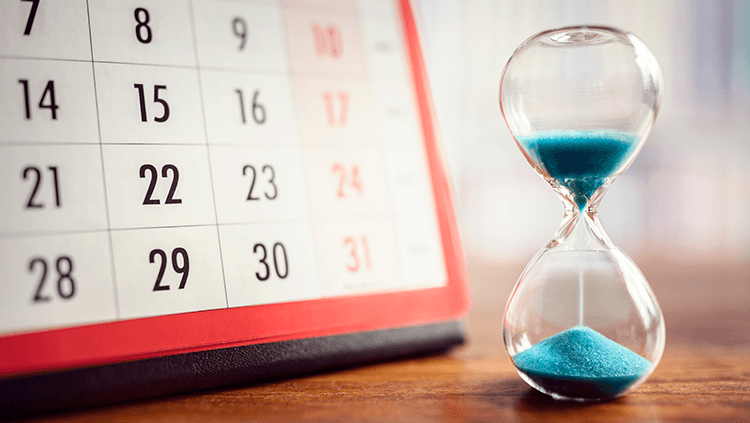 Sand hourglass next to a calendar