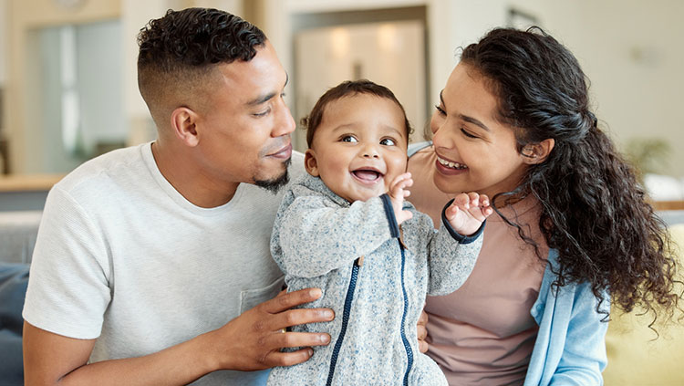 Family holding baby smiling