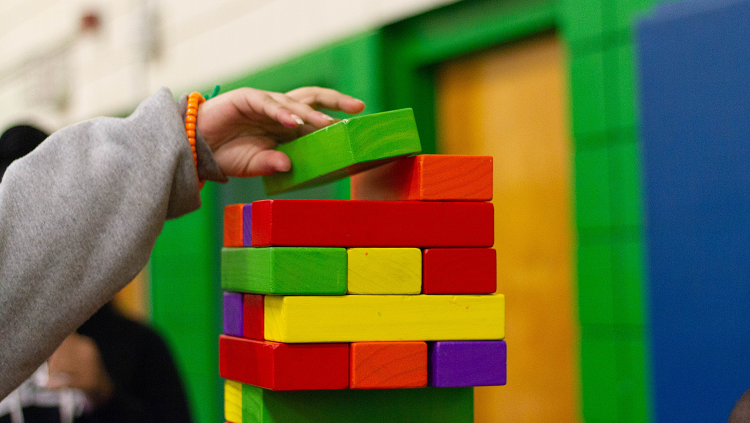 young child building with colorful wooden blocks