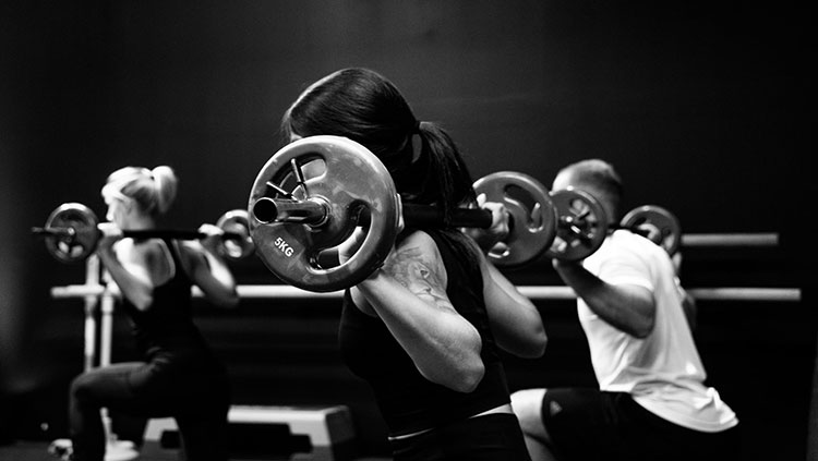 woman with barbell on shoulders