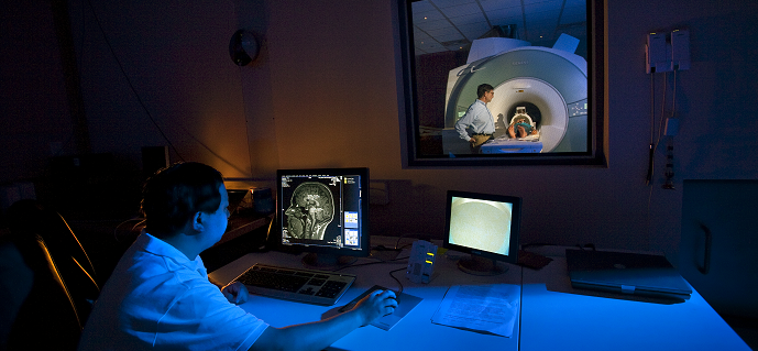 Man monitoring a child in an MRI scanner.