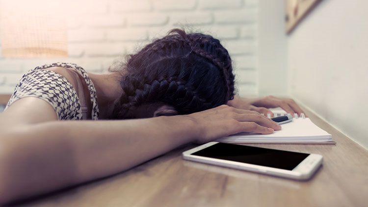 Girl with her head down on a desk