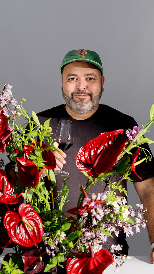 Michal Kowalski posing with flowers and wine