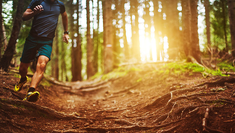 Man running on trail in the forest