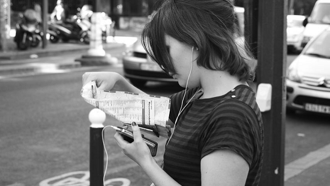 Woman looking at map and listening to music.